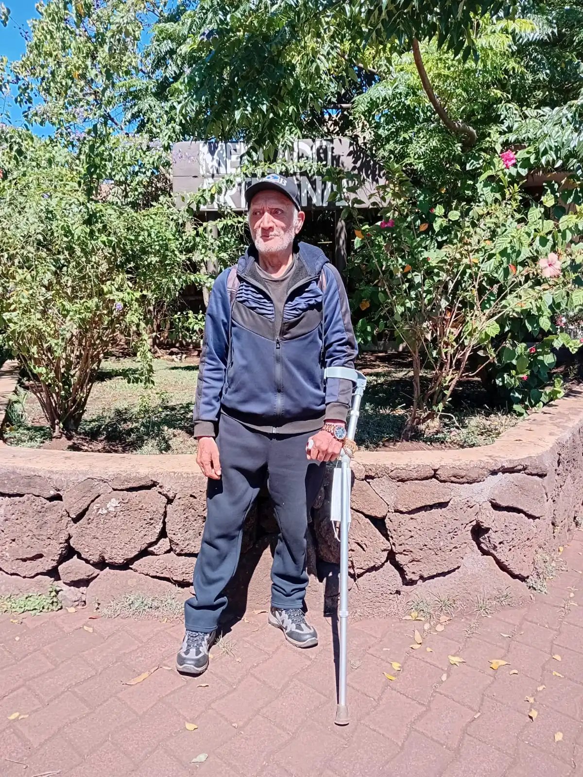 Elderly Rapa Nui man walking with a cane outside the Mercado Artesanal on Easter Island